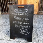 虹の仏 - ところが店頭にはこんな案内が。こちらがお店の正面にはなるようだが、入店は裏側からになるらしい。