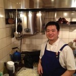 クスクス ルージール - 新しい換気扇設備の前でニッコリの金子シェフ