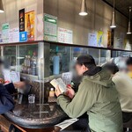 中華料理 末広 - カウンターはガラス越しの厨房を囲むようにＬ字形の配置