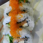 サーモン、キュウリ、水菜、チーズが入っていて、トビコがトッピングされたロール