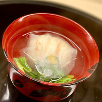 おか田 - ❸椀物
                      〜蟹真薯、縮みほうれん草、大根。出汁は本枯れ節にスッキリした甘味を感じる。薄い大根は冬の氷に見立てて透き通った中には蟹真薯が美しい。この蟹真薯はすべてズワイ蟹身なのでめっちゃ食べ応えがある。