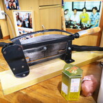 カナ - 硬いイラブーの燻製を裁断するための器具。カットする作業に限らないが、力仕事が推察される