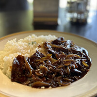 洋食 つばき - 深みあるコクと酸味のバランスが絶妙なソースに、食感をたっぷりと残した玉葱。
                    すき焼きほどの厚さもあろうかというお肉が、贅沢に使われていて、これまた昇天ものなのです！