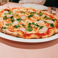 La Terrazza SABATINI - エビと菜の花、モッツアレラのトマトソースピッツァ。薄めの生地で軽い食感だけど石窯焼きの火力もしっかり感じられ、味のバランスが良い一品。
