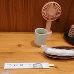 うなぎのまとい - 焼き台の目の前のカウンター席に小型の扇風機が…