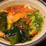 Sake Baru - サーモン切り身、イクラ、鶏卵、若布、飛子、茗荷が出汁に使った状態で小さな摺鉢に入っています