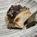 鮨匠 のむら - ⑫黒鮑(佐賀県唐津産)、肝添え
      産卵期は秋～冬、旬は初夏～夏
      4時間、大根を摺り卸した煮汁と日本酒で焚き込んだ黒鮑は、軟らかくも弾力があり、磯の香りと旨みが拡がります