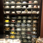 自家焙煎珈琲 凡 - 戸棚に並んだティーカップたち。意匠を凝らしたデザインが素敵です。