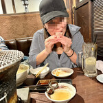 炭火焼肉ホルモン うらら - 牛テールスープの骨側のお肉を夢中で食べる可愛い友人