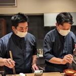 飯倉 からき - 料理長の手元を見つめる山田くん