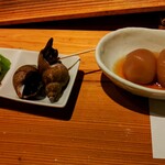 Yaegiku - お通し、三種類です、漬物・黒バイの煮付け・玉こんにゃく