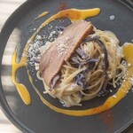 Spaghetti with smoked duck breast and truffle oil, topped with Parmesan cheese