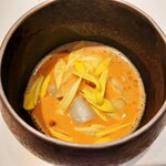 Grand rocher - 花びらを浮かべた華やかなスープは、深みのあるブイヤベースに魚介や卵黄のコンフィ入り