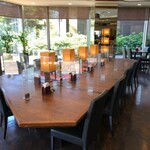 レストラン ラ･ベランダ - 台形の囲みテーブル。温かい陽が当たる大きいテーブルはお一人様利用者にも人気のゆったりシート