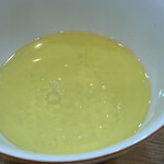 らぁ麺 飯田商店 - しおつけ汁 鶏出汁スープにレンゲで2杯たっぷりと鶏油を注ぎ黄金の輝き