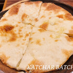 カッチャル バッチャル - チーズクルチャ。小麦ベースの生地にチーズをたっぷり挟んだ、シンプルなピザのような一品。熱々のカレーに入れるとチーズが良い感じに溶けて、それがまた止まらなくなる美味しさです。