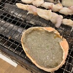 磯丸水産 - 名物！カニ味噌甲羅焼きとツブ貝の串焼き