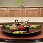 御料理 寺沢 - 北上牛のフィレ肉と蕨の八幡巻､鱸の木の芽焼､自家製の鯨ベーコンに唐墨の炙り､行者大蒜薄衣揚げ､チェリートマトの蜜煮､海鼠酢､鮑の柔らか煮､茄子の揚げ浸しの生海胆載せ