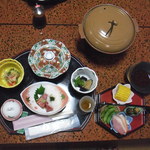 憩山荘 - 夕食全景：黄色の器（菊の花や胡瓜の酢の物）、蓋付き器（南瓜や隠元豆の煮物）、茄子や獅子唐の揚げ浸し等、蓋付きの黄土色の入れ物内では豚肉等の焼き物