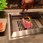 焼肉うしごろ - 茨城県産の大判サーロインを鉄板の上で焼いている様子・その２です。