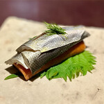 アカ - ❷小肌のボカディージョ ～スペシャリテである美しい小肌に魅入られた逸品。トマトを練り込んで焼きあげマリネしたトマトパンと小肌を大葉を包んで。握りのような酸味ある小肌とトマトパンが絶妙なマッチング。