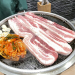 samugyopusarutokankokuryouritsutsumusampa - 鉄板に肉とニンニク、キムチが載せられました