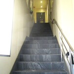 レミニセンス - 歩道から2階のガラス扉へと続く階段。