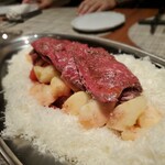 グルマンディーズ - 牛のカルパッチョ ～ パルミジャーノ・レッジャーノ、白桃、オリジナルオリーブオイル、塩