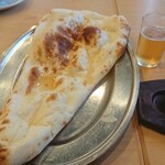 つきカレー&ナンハウス - バターナン。バターの溶けたのがかかっている。美味しいけど食べるごとに指先を拭きたくなるのはどうすればよいんだろうか