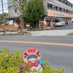 オランチョ - 店舗前の道路沿いに、カイツブリのキャラクター看板