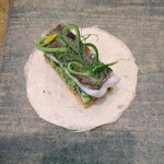 レヴォ - 〜太刀魚〜焼いた太刀魚、石川県の伝統野菜・加賀太胡瓜（かかぶときゅうり）のミルフィーユ、トリュフソース、和紙の皿に乗せて