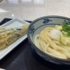 Miyatake Sanuki Udon - 生醤油と茄子の天ぷら。
                小腹を満たすには、なかなかいい組み合わせ♪
                
                ベルトコンベヤー方式でレジまでたどり着くまでの間に、
                天ぷら&おにぎりゾーンに突入するわけですが、
                何かしら取らずには居られない…