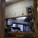 軍鶏ラーメン美幸 - カウンター席、厨房。メニューが壁に貼られています。
