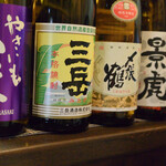 大納言本家 - カウンターに並ぶ焼酎と熱燗用の日本酒