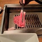 焼肉うしごろ - 牛脂を塗った鉄板の上で、大判サーロインを焼く様子・その１です。