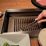 焼肉うしごろ - 鉄板の上に、牛脂を塗る様子です。