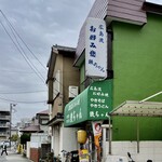 お好み焼き 鉄ちゃん - 商店街の角を左に曲がると見えてくる緑色の庇と看板