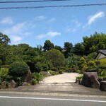 暁山 - 入口外観((右手の家ではなく)木々の向こうに隠れるように立つ家屋が店とばかり思っていたが、店は奥から左手の細い道を進んだところだった。)