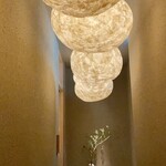 千葉たかおか - 落花生を模したオブジェのライトからは、温かみのある光が柔らかく明るく照らしています。
      壁は高岡さんの畑の土を使った土壁、自然に湿度を調整してくれる先人の知恵です。