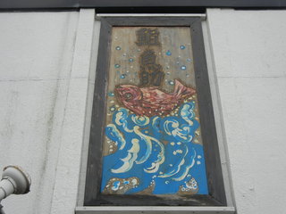Sushiuosuke - 店を見上げると一枚板に彫られた大きな鯛が。