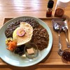 紅茶とクラフト酒のお店 タイフーン - 日食カレー２種盛り（ベーシックな赤の有機カルダモン&黒胡麻ベースの黒カレー）（税込1200円）