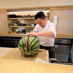 鮨 一二郎 - 入店早々、お弟子さんのスイカ割りショー！デザートの仕込みの最中。見事な包丁捌き！