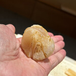 鮨 西崎 - 藁で燻した帆立。
      帆立の裏には、ふんわりと柔らかく握られたシャリが隠れています。
      もちろん、抜ける薫香が心地いい〜。