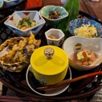 大和薬食処 ならやま茶館 - 黄色い器から時計回りに冬瓜と枝豆のジュレ、もずくととうもろこしのかき揚げ、鱧と苦瓜の酢みそ、茄子とにしんの山椒煮、そうめん南京の酢の物、ずいきの小鉢、真ん中は生姜の漬物。