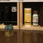 Tokyo Ajifurai - 調味料は左から…ソース、醤油、甘口醤油、パルメザンチーズ、雪塩。手前の瓶には青唐辛子の醤油漬け。