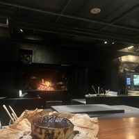 薪焼 銀座おのでら - チーズケーキはしっとりこっくりなお味で最高でした。後ろの薪も素敵でした。店内が薪の香りで包まれて非日常を感じられます。