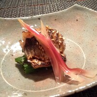 やすい - 焼き物： カマスを甘辛い味付けで ふっくらと焼き上げてあります。 白胡麻を振って、下には万願寺唐辛子が敷かれており、酢漬けの茗荷が 美しくあしらわれています。