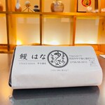 Unagi Hana - 鰻弁当。掛け紙のロゴは何に見えますか？