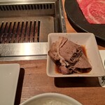 焼肉うしごろ - 焼いた鹿児島県産の大判サーロインを、おろしポン酢に浸けた様子です。