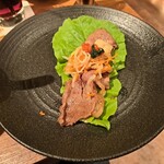 焼肉うしごろ - ハサミで半分に切り、ポン酢に浸けた大判サーロインをサンチュの上に敷き、ナムルやニンニク焼きなどをのせたもの・その2です。